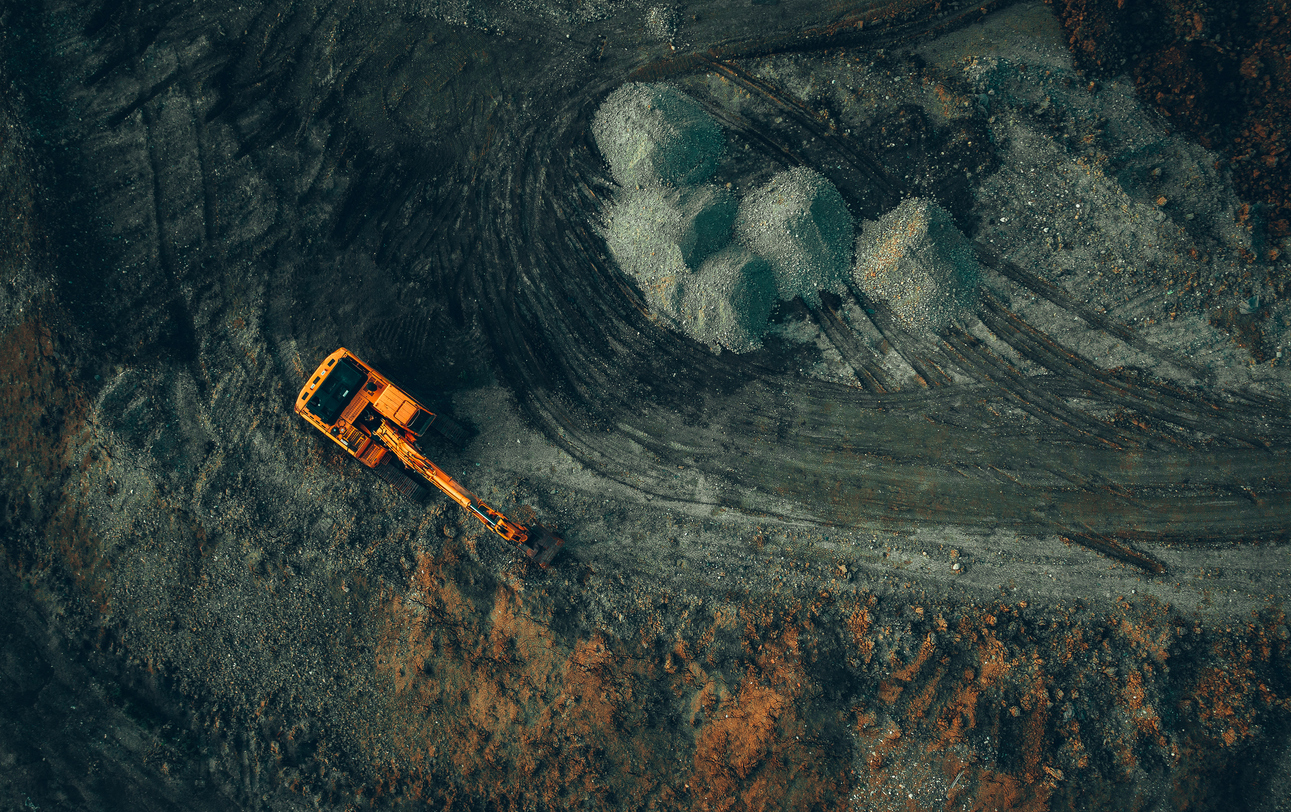 bright-excavator-at-work-on-a-dark-background-view-from-a-drone